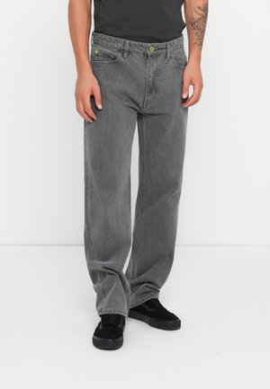Gray denim jeans with a relaxed fit, featuring green hardware and front pockets. The material has a soft texture with a slightly faded finish.