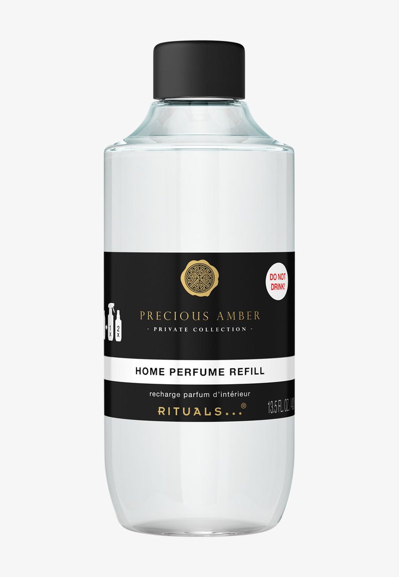 Transparante glazen fles met een zwarte dop, voorzien van zwart-witte labels. De tekst bevat "HUISPARFUM NAVULLING" en een waarschuwingslabel.