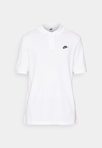 Polo blanc en coton avec col, manches courtes et logo Nike noir sur le côté gauche de la poitrine. Texture lisse avec une coupe standard.