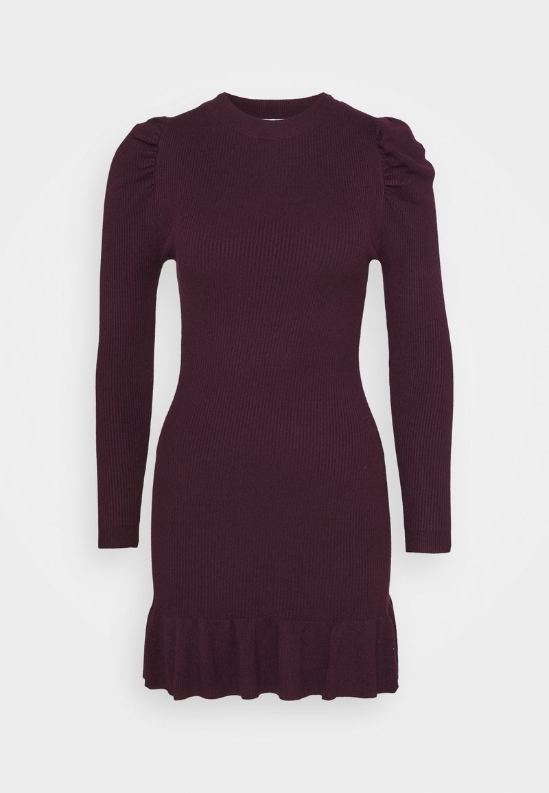 Robe tricotée en bordeaux foncé avec des manches longues, un corsage ajusté et un ourlet à volants. Présente une texture côtelée et des épaules froncées.