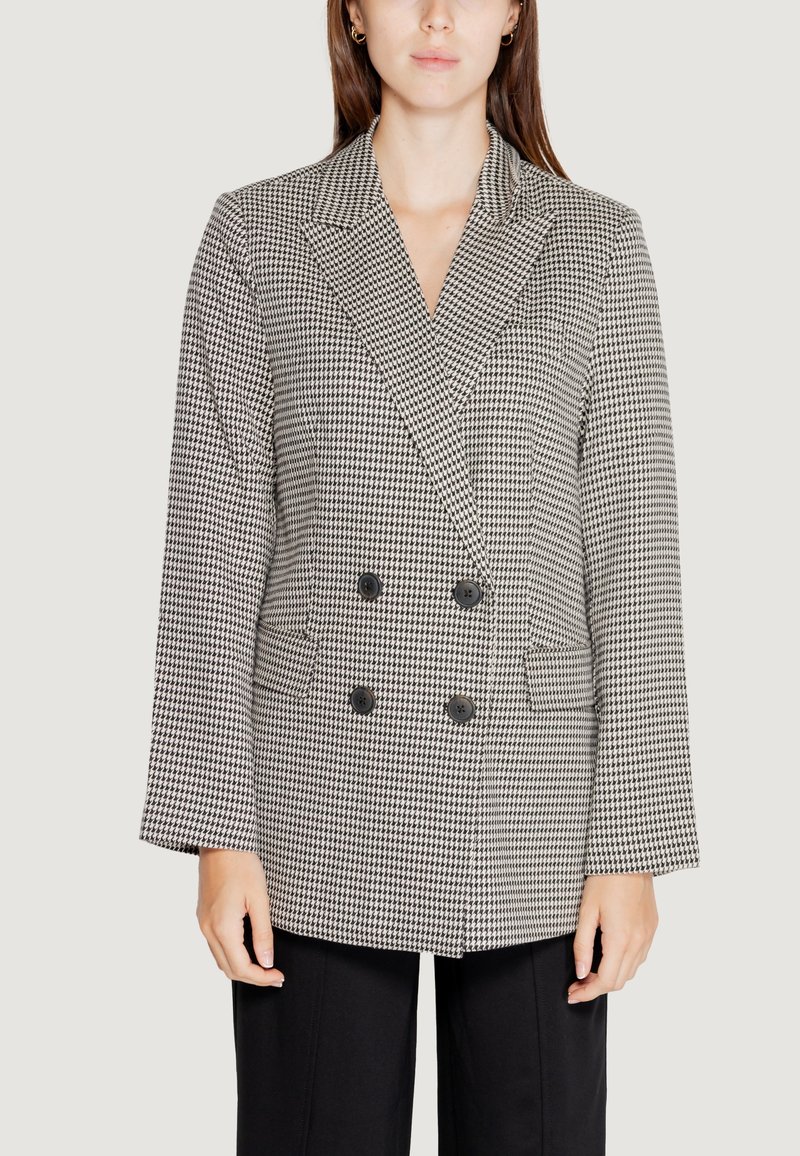 Blazer doppiopetto in stile houndstooth bianco e nero. Presenta rever a punta, due tasche frontali e bottoni neri. Texture liscia.