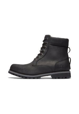 Bottine en cuir noir avec lacets à l'avant, col rembourré, semelle robuste et logo d'arbre embossé sur le talon.