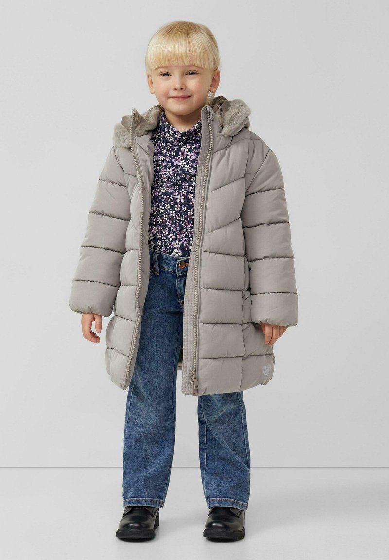 Szara puchowa kurtka z kapturem wykończonym futerkiem, z pikowanym wzorem i sercowym akcentem. Połączona z kwiecistą bluzką i jeansami.