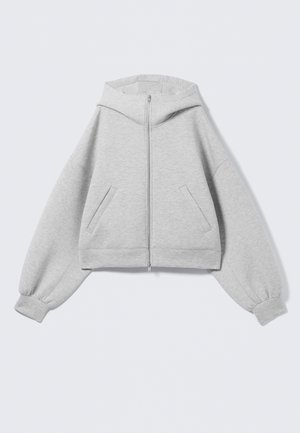 Sweat à capuche gris clair zippé avec manches surdimensionnées, poignets côtelés, une capuche et deux poches inclinées à l'avant.