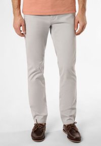 Chinos gris clair avec une coupe slim, en coton lisse, et à devant plat. Associés à des chaussures bateau marron pour le contraste.