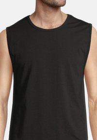 Black sleeveless t-shirt made from soft cotton, featuring a rounded neckline and a smooth texture. Minimalist design without patterns or accents.