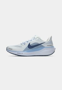 Svetlo modri športni čevlji iz mrežastega materiala z temnejšim modrim logotipom Nike, teksturirano zgornji del, bel podplat in ojačan prst. Imajo oblazinjeno zasnovo.