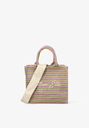 Meer kleursgewoven draagtas met zigzagpatronen, dubbele handvatten en een beige schouderriem over de voorkant gedrapeerd.