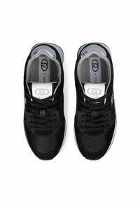 Chaussures de sport noires avec tige en mesh et daim, bout rond, lacets plats, col rembourré et détails de logo sur la languette et les côtés.