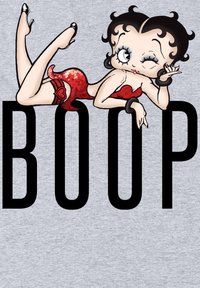 Tecknad karaktär i en röd paljettklänning, med svarta accessoarer, på en ljusgrå bakgrund, bredvid fet stiltext som säger "BOOP."