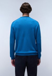 Maglione blu realizzato in tessuto morbido, con colletto tondo, maniche lunghe e orlo a costine. Dettaglio notevole: piccolo logo sopra il collo sul retro.