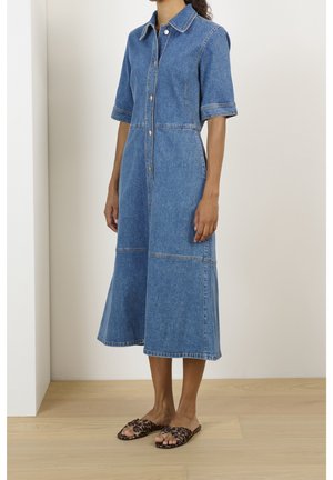Denim overhemdjurk met korte mouwen, knoopsluiting en een uitlopende rok tot op de knie. Voorzien van contrasterende stiksels en een klassieke kraag.