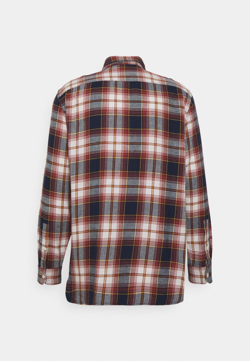 Chemise à manches longues boutonnée à carreaux dans des tons bleu marine, blanc, gris et rouge, vue de dos sur un fond uni.