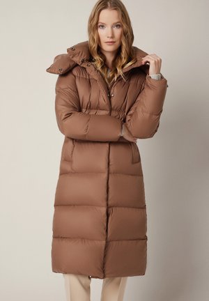 Brązowa kurtka puchowa o strukturalnym kroju, z dużym kapturem i zapięciem na napy. Posiada poziome pikowane sekcje i średnią długość.