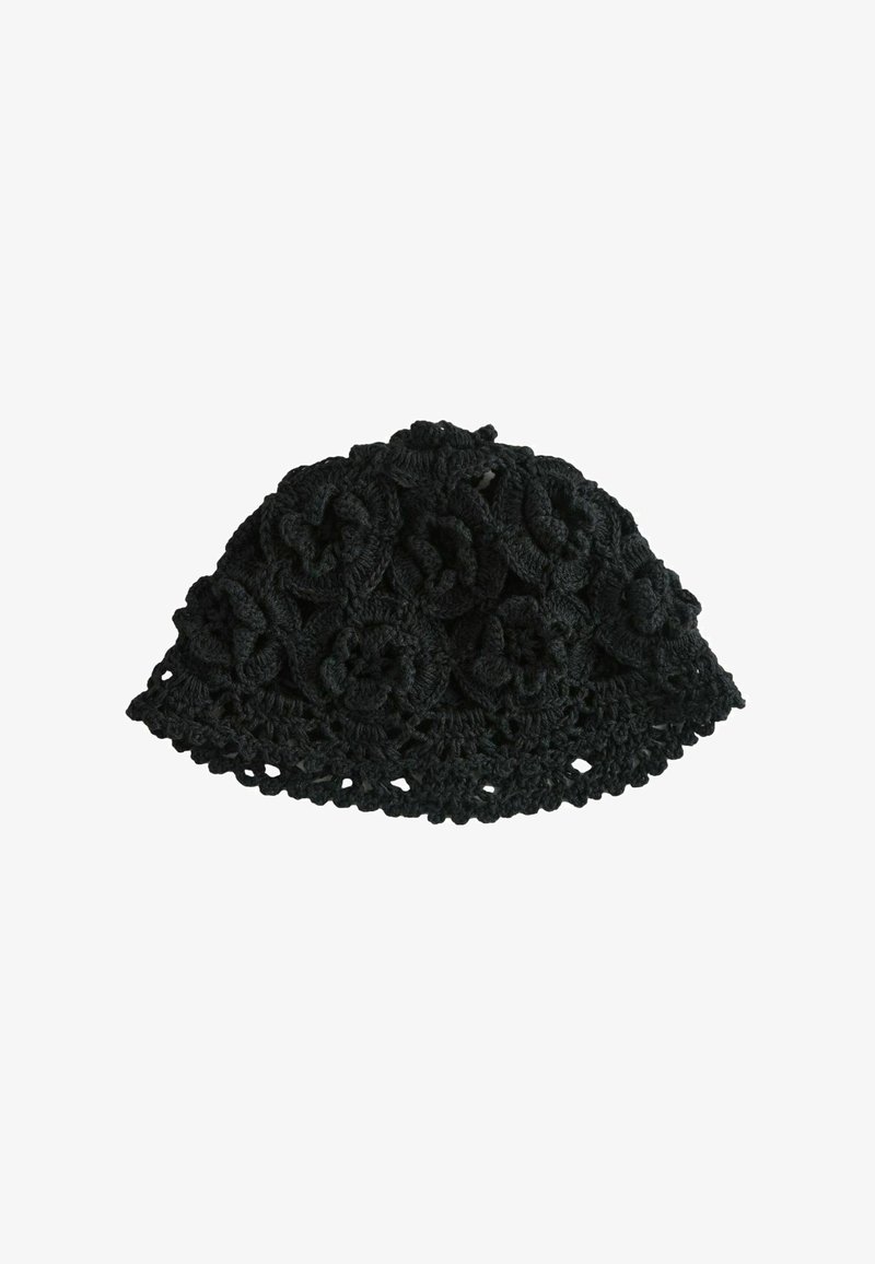 Bonnet noir au crochet avec un motif floral et un bord festonné, vu de dessus sur un fond blanc.