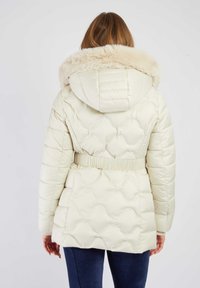 Gewatteerd jack in lichtcrème met een gevoerde capuchon met bont, een gewatteerde textuur, een getailleerde taille en lange mouwen, weergegeven van de achterkant.