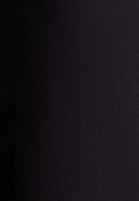 Tessuto scuro con un motivo intrecciato e testurizzato. Il colore appare come un blu navy intenso o nero, con una superficie liscia e uniforme.