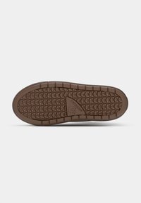 Semelle de chaussure Converse marron avec motif diamant et logo au centre sur fond clair.