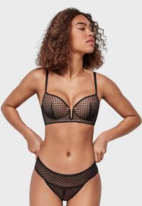 Black mesh lingerie set featuring a structured, diamond-patterned bra with underwire and high-cut briefs, highlighting sheer texture and adjustable straps.