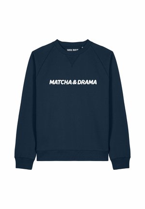 Felpa blu navy con maniche raglan, caratterizzata da un testo bianco "MATCHA & DRAMA" sulla parte anteriore. Tessuto morbido, design casual.