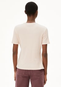 Korte mouwen, lichtroze structuurshirt met een ronde halslijn, gecombineerd met diep bordeauxrode broek met achterzakken.