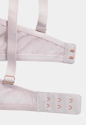 Light pink bra strap made of soft fabric with adjustable straps and a hook-and-eye closure featuring rose gold hardware.