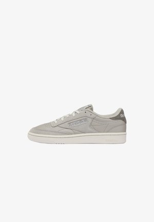 Lichtgrijze Reebok lage sneaker met suède accenten, vetersluiting aan de voorkant en een gestructureerde zool, zijaanzicht op witte achtergrond.
