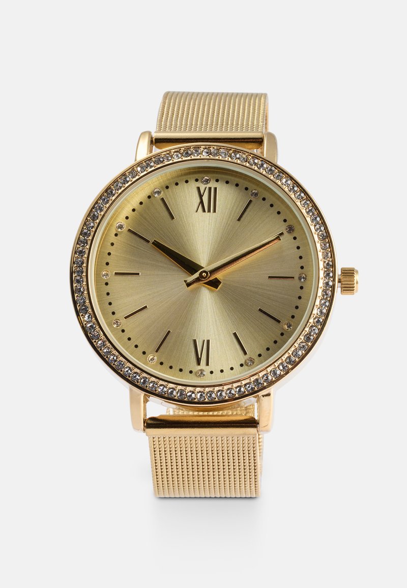 Orologio dorato con cassa rotonda, quadrante in oro testurizzato, indicatori delle ore e accenti di cristallo. Presenta un cinturino a rete e una corona sul lato.