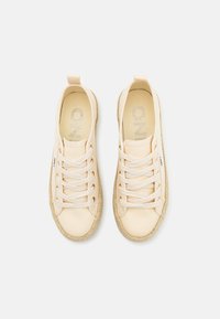 Paire de chaussures décontractées en toile beige à lacets avec semelles en corde tressée, vues de dessus sur un fond clair uni.