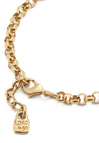 Pulsera de cadena de oro con eslabones ovales grandes, con cierre de langosta y un pequeño charm de candado marcado con "UNO de 50". Textura lisa.