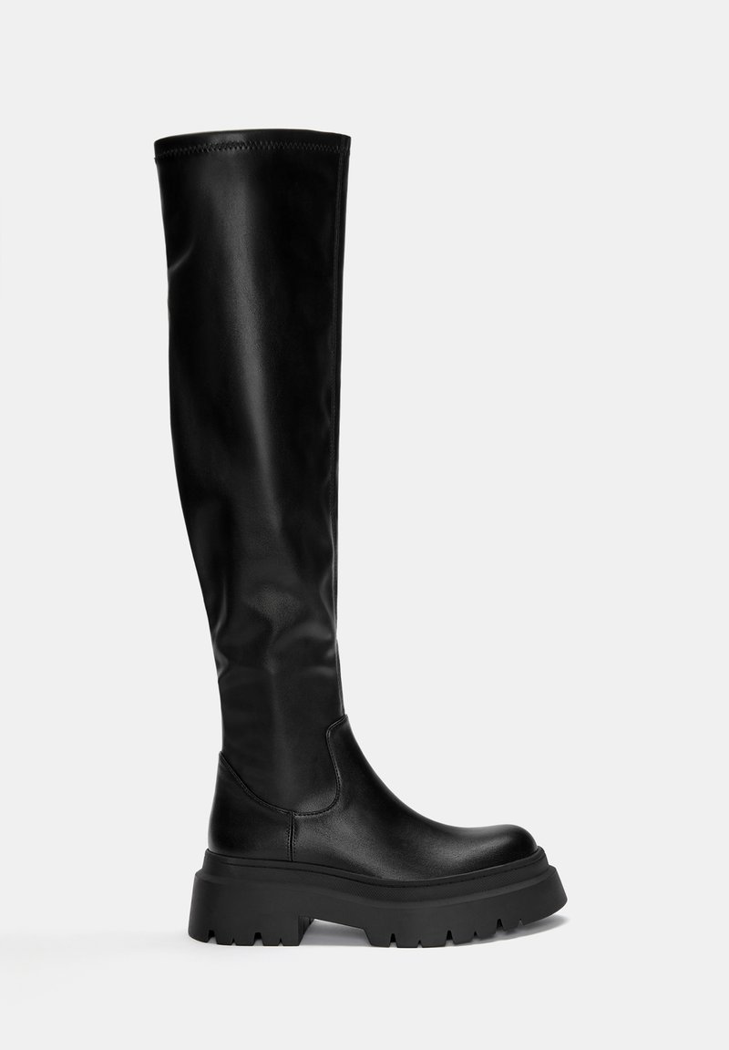 Stivali neri al ginocchio con una finitura in pelle lucida, suola in gomma spessa e texture liscia. Presentano un design elegante e minimal.