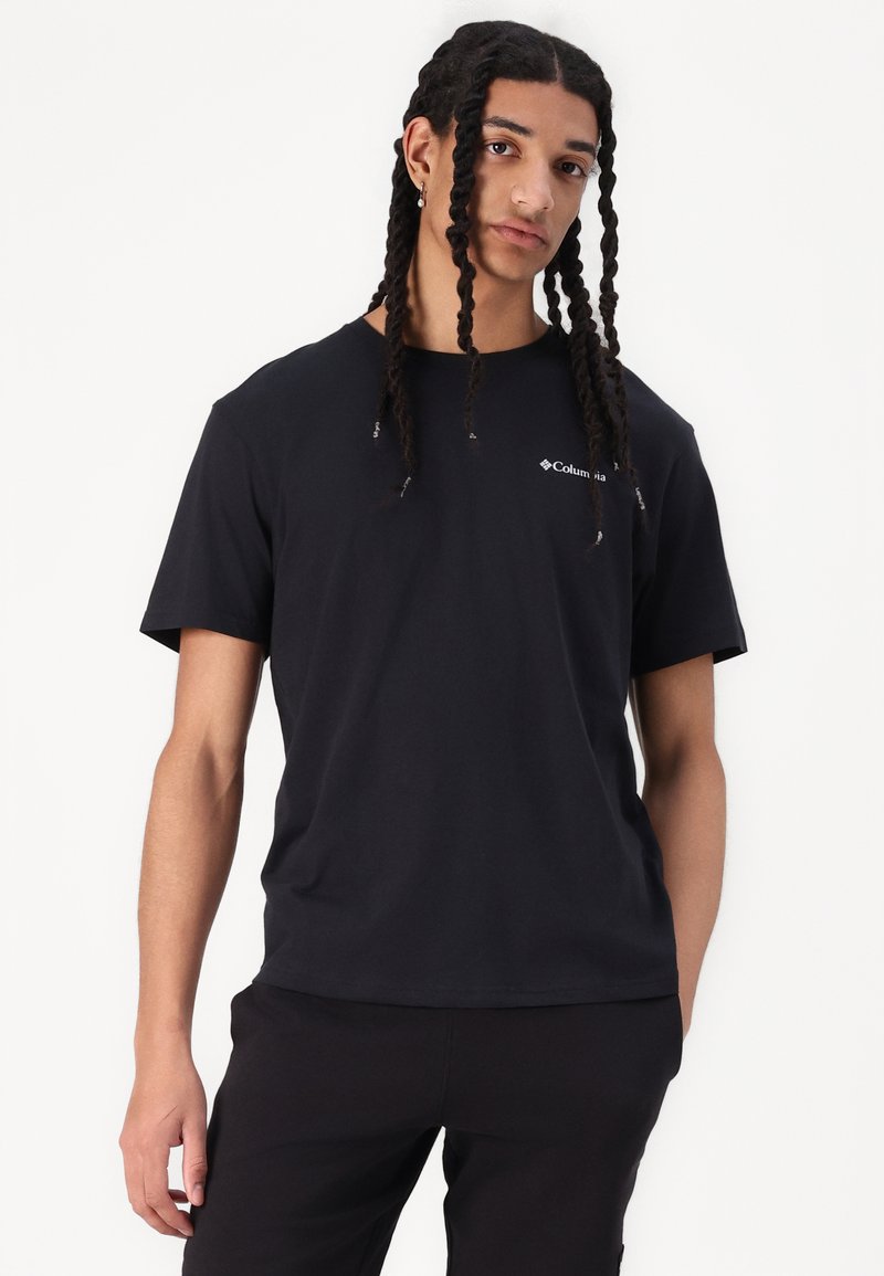 T-shirt noir à manches courtes en coton, avec un col rond et un petit logo blanc dans la partie supérieure gauche de la poitrine. Texture lisse.