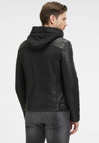 Zwarte leren jas met een capuchon, gewatteerde schouderaccenten en een getailleerd ontwerp. Kenmerkt zich door een gladde textuur en een gestructureerde silhouette.