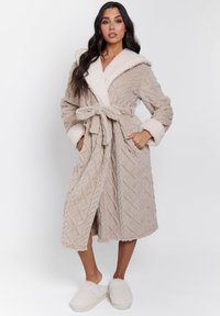 Beige, lange robe met een gestructureerd patroon, pluche stof, sjaalkraag en bijpassende riem. Heeft zijzakken en een gezellige, zachte uitstraling.