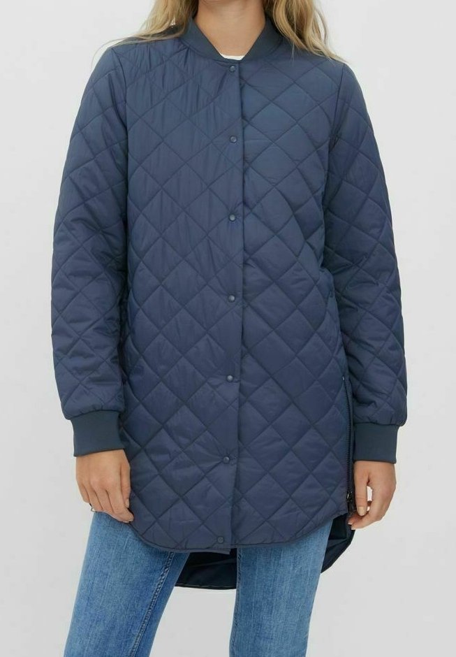 Marinblå vadderad lång kappa med rund krage, knappstängning och ribbade ärmmuddar; med diamantmönster och förlängd bakslut. 