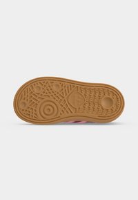 Καφέ λαστιχένια σόλα παπουτσιού Adidas με γεωμετρικά και κυκλικά σχέδια πέλματος και το λογότυπο της Adidas στο κέντρο.