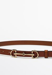 Bruine leren riem met een goudkleurige metalen gesp en lus. Heeft een gladde textuur, meerdere gaatjes voor aanpassing en een slank ontwerp.