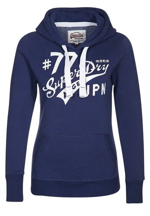 Marineblauwe Superdry hoodie met witte trekkoorden, zak aan de voorkant en witte geprinte tekst en logo op de borst.