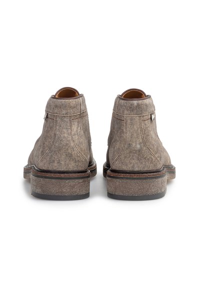 Pair of brown suede ankle boots shown from the back with thick soles and visible stitching details on a white background.