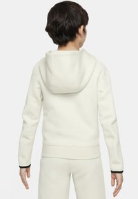 Sweat à capuche blanc en mélange de coton avec un poignet et un ourlet noirs, vue arrière montrant une poche kangourou et une capuche réglable. Texture lisse.