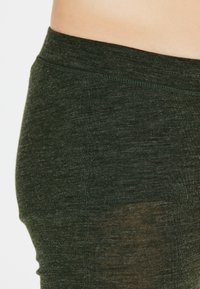 Gröna, figurnära leggings med en texturerad tyg. Har en bred midjeresår och en subtil lyster som framhäver ett mjukt, melerat mönster.