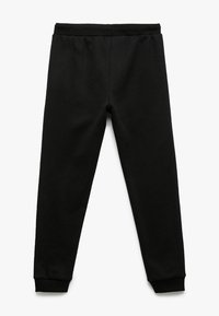 Zwarte sweatpants van zacht materiaal, met een elastische tailleband en boorden bij de enkels, met een gladde textuur en zonder zichtbare patronen.
