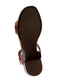 Braune Sandalensohle mit strukturierter Oberfläche; verfügt über ein breites, abgerundetes Zehendesign und ein Knöchelriemen-Design. Robuster und flacher Absatz für Unterstützung.