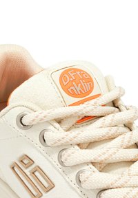 Sneaker bianco in suede con accenti testurizzati. Presenta una patch con logo arancione e lacci intrecciati. Include occhielli metallici e una punta liscia.