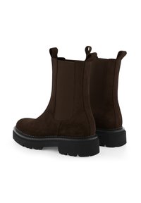 Braune Wildleder-Stiefeletten mit elastischen Seitenteilen, Zuglaschen, groben schwarzen Gummisohlen und glatter Textur.