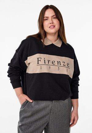 Sweatshirt noir avec une rayure beige portant l'inscription "Firenze 1951". Le col est beige et le tissu semble doux. Pantalons rayés gris.