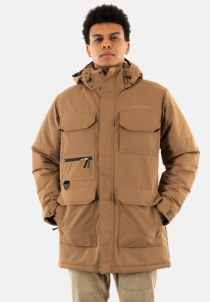 Chaqueta aislante marrón con capucha, múltiples bolsillos frontales, secciones con cremallera y cordones ajustables. Fabricada con material resistente a las inclemencias del tiempo.