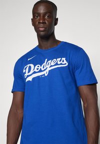 Maglietta in cotone blu con logo bianco "Dodgers", colletto rotondo, maniche corte e logo Nike a sinistra.