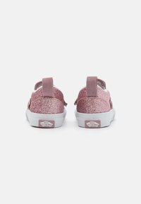 Rozā mirdzošas slip-on kurpes ar gaiši rozā siksnām, baltām zolēm un Vans logotipu uz papēža. Gluda tekstūra ar spīdīgu apdari.