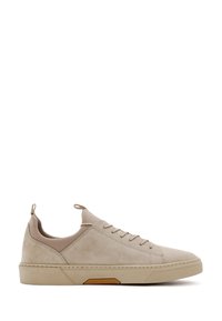Sneaker in suede beige con una texture liscia, a profilo basso, punta rotonda e suola in gomma a contrasto; presenta lacci e un tirante sul retro.